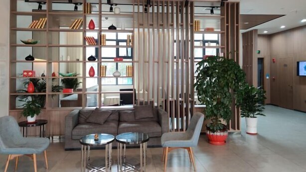 A modern interior with a sofa, two chairs, a small table, and a large potted plant. - Jinjiang Inn Select (Taixing Runtai South Road) (Taixing)