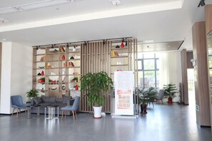 A modern lobby with a seating area, a large plant, and a bulletin board. - Jinjiang Inn Select (Taixing Runtai South Road) (Taixing)