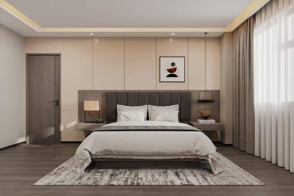 A modern bedroom with a large bed, bedside tables, a wall-mounted artwork, and a window with curtains.
