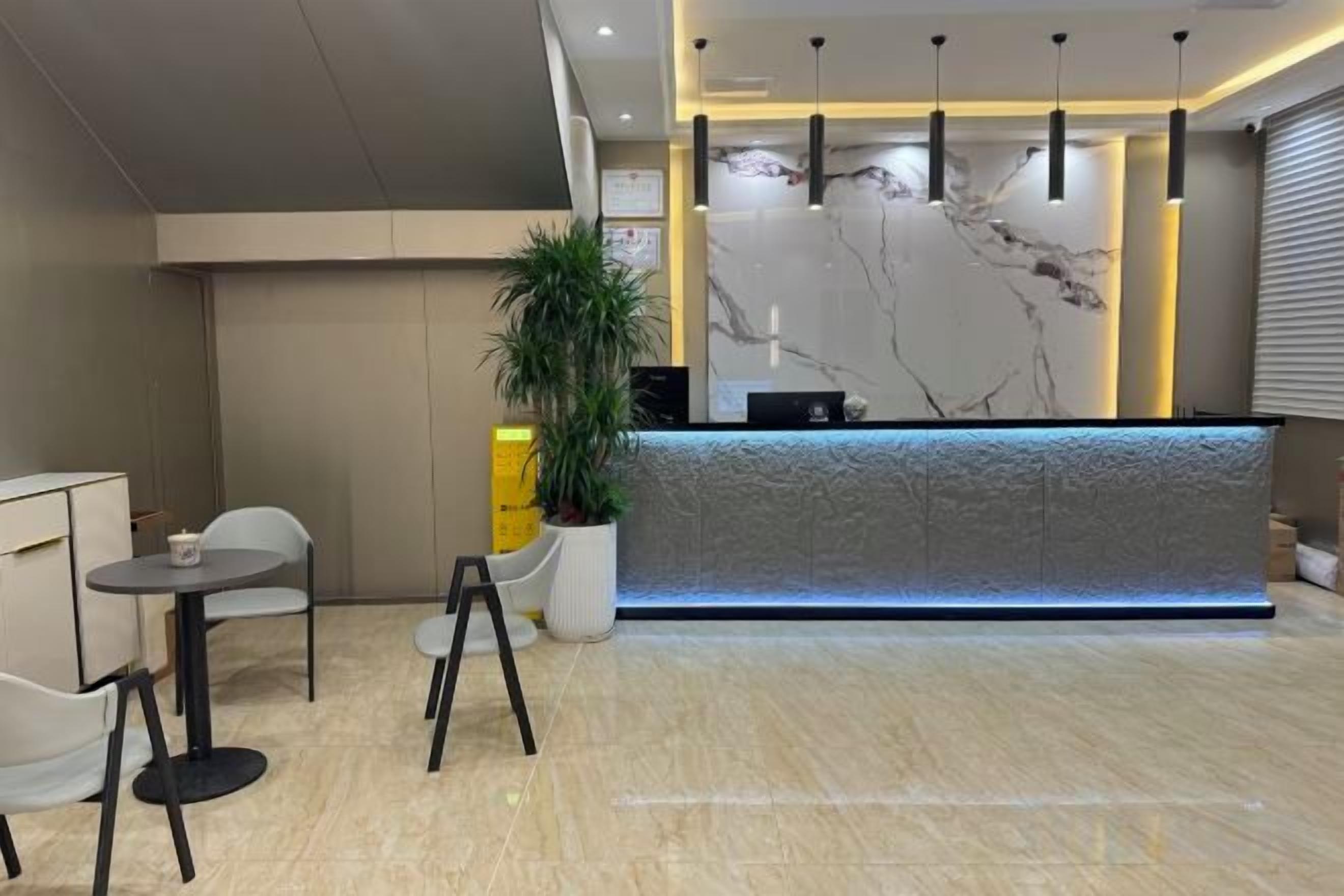 A reception area with a marble reception desk, seating arrangements, and a potted plant.