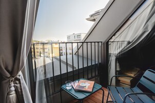 A balcony with a table, a chair, and a magazine.