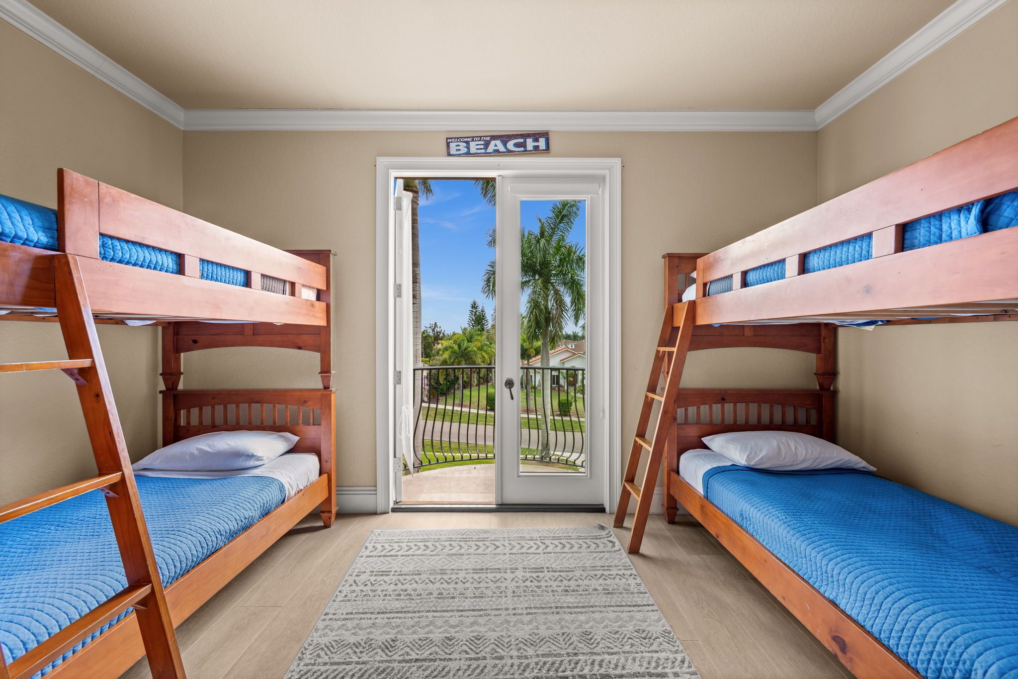 A room with bunk beds, a door leading to a balcony, and a sign reading 'BEACH'.