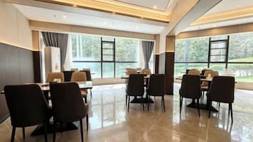 A conference room with a large table and chairs, large windows with curtains, and a modern ceiling design.