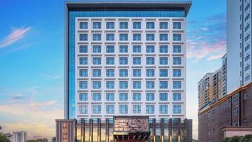 Un hotel de gran altura con fachada moderna, varios pisos y una entrada destacada.