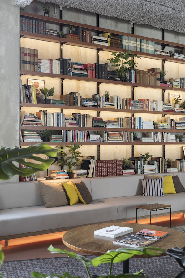 A cozy living area with a bookshelf, a sofa, and a coffee table. - YUST Liège (Liege)