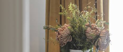 Una mesa con un florero, una lámpara colgante y un candelabro a rayas.
