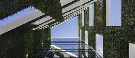 A modern architectural structure with a glass floor and green walls.