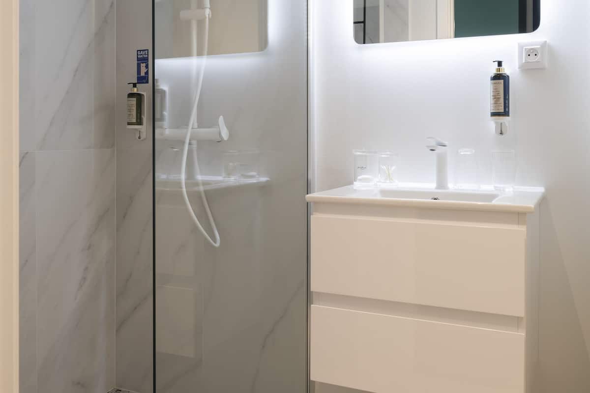 shower, hair dryer, towels, toilet paper