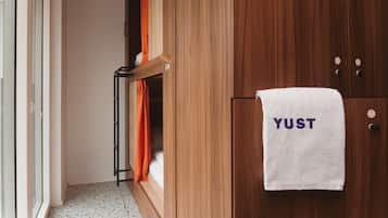 A wooden wardrobe with a white towel hanging on it that reads "YUST".