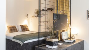 A modern bedroom with a bed, bedside table, and a large mirror. - YUST Liège (Liege)