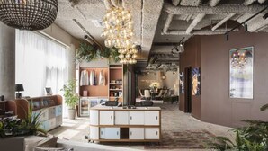 A modern living room with a sofa, a coffee table, and a decorative hanging light fixture. - YUST Liège (Liege)