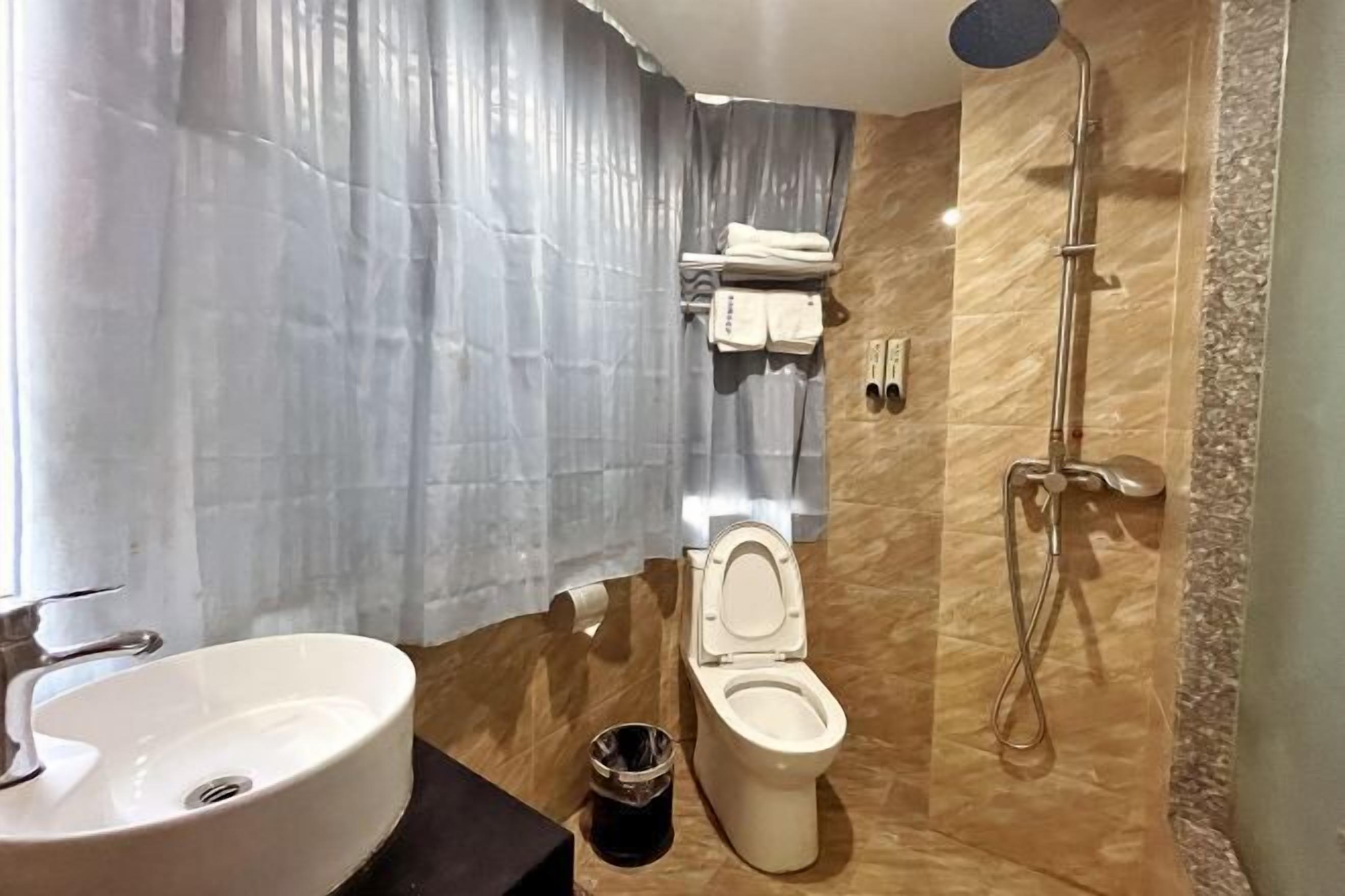 Un baño con lavamanos, inodoro y ducha.
