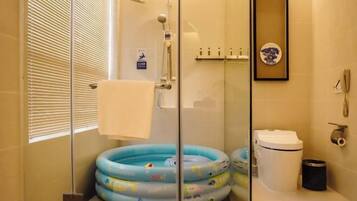 Un baño con cabina de ducha de vidrio, inodoro, lavabo y un cuadro en la pared.