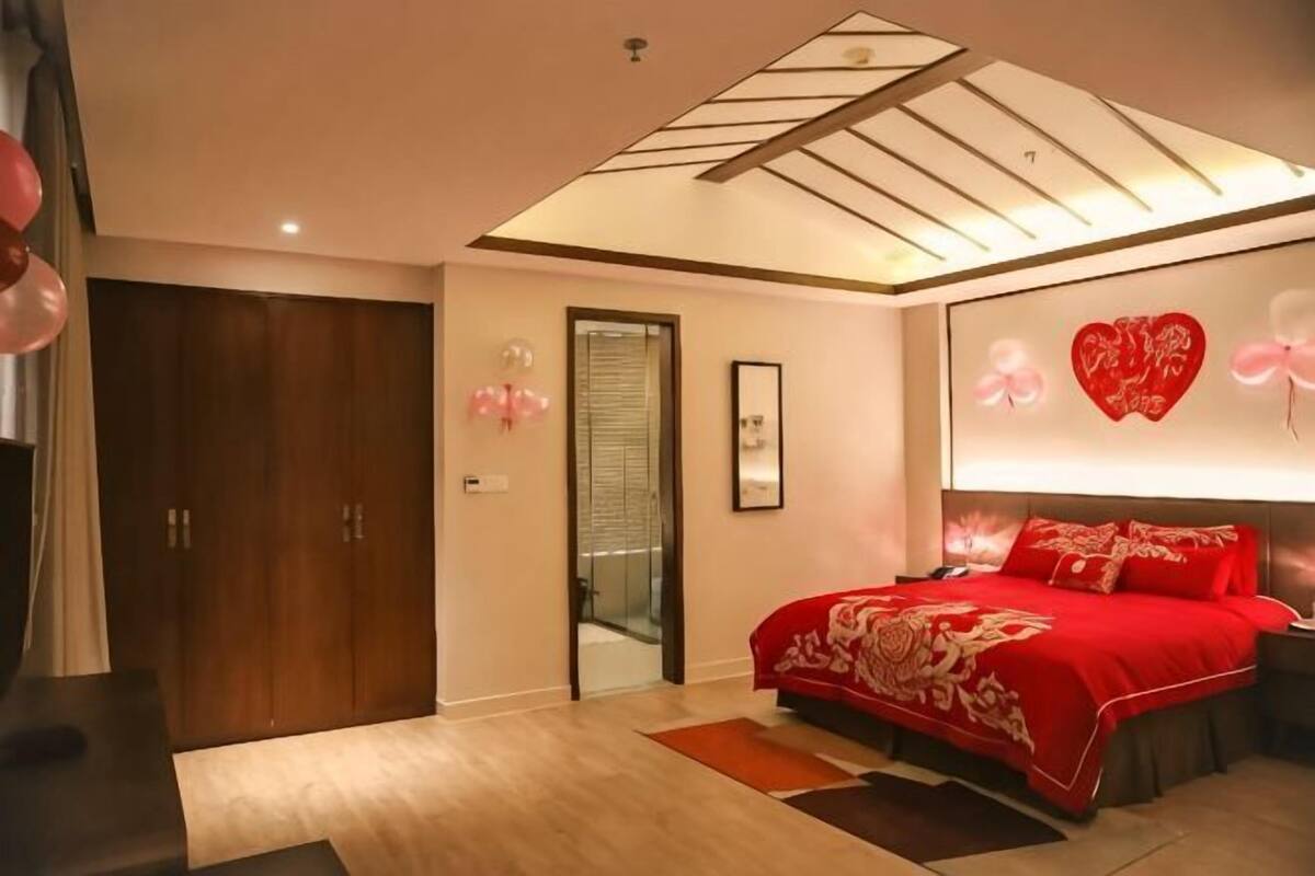 Ein Schlafzimmer mit Bett, Kleiderschrank, Tür und Deckenleuchte.