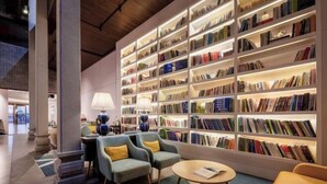 Una biblioteca moderna con estanterías, asientos cómodos e iluminación ambiental.