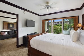 Une chambre d’hôtel avec un grand lit, un ventilateur de plafond, une télévision, un canapé et une vue sur l’extérieur.