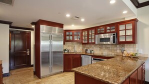 Une cuisine moderne avec des meubles en bois, des appareils en acier inoxydable et un plan de travail en granit.