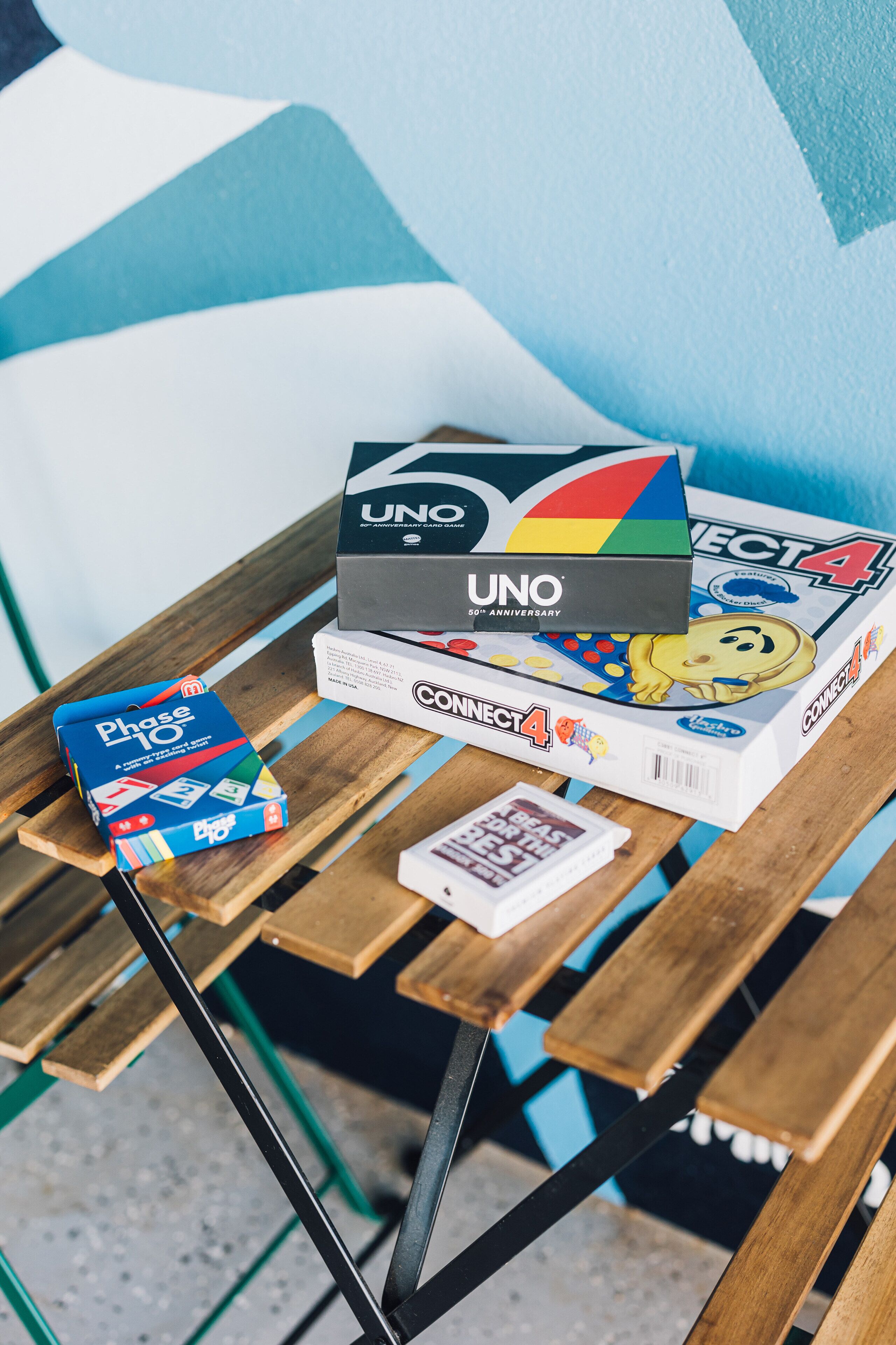 A wooden table with a board game, a book, and a small card.