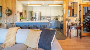 A cozy living room with a sofa, a coffee table, and a fireplace. - Gated Carmel Valley Retreat with 20 Acres, Pool & Hot Tub (Carmel Valley)