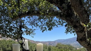A wooden deck with a pool, surrounded by trees and a mountainous backdrop. - Gated Carmel Valley Retreat with 20 Acres, Pool & Hot Tub (Carmel Valley)