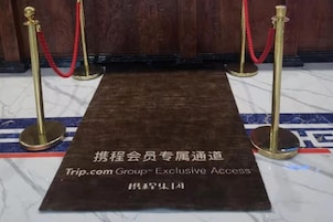 Un espacio con alfombra y un letrero que indica acceso exclusivo para miembros de Trip.com Group.