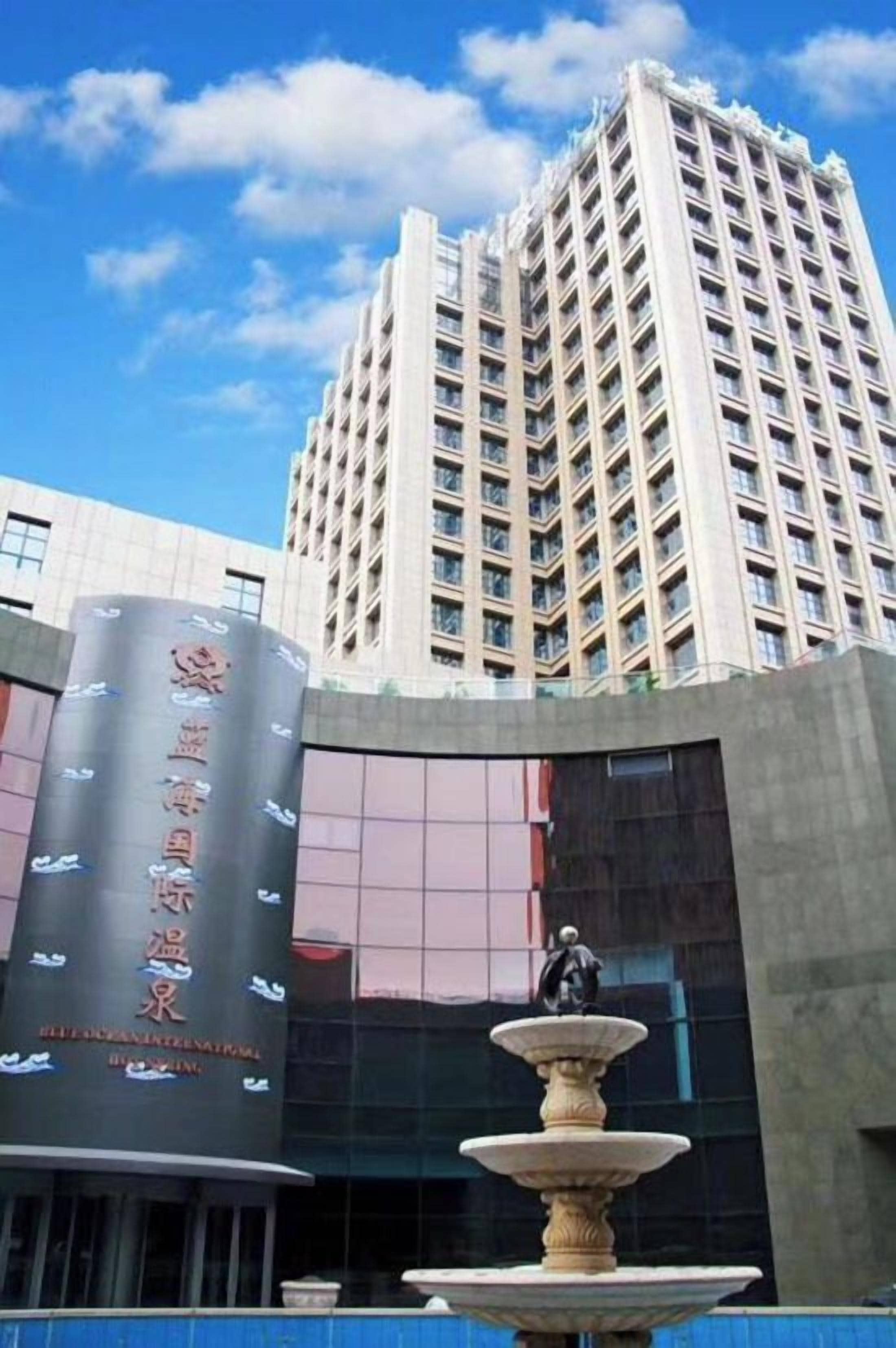 A tall building with a fountain in front.