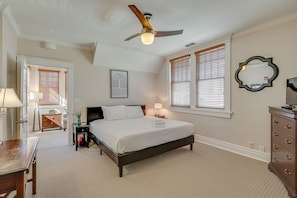 A bedroom with a bed, a desk, a dresser, a ceiling fan, and a window with blinds. - Historic 4-Bedroom Manor | Walk to Music Row & Vanderbilt | Family Retreat (Nashville)