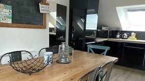 Eine moderne Küche mit einem Holztisch, Metallstühlen und einer Tafel mit einem Schild.