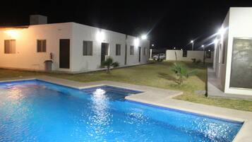 A swimming pool area with a white building in the background.