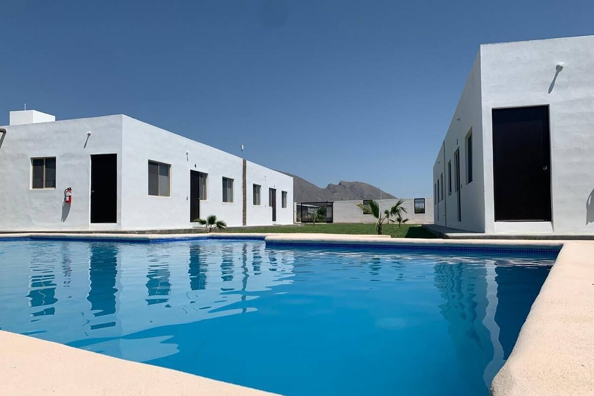 A modern building with a swimming pool in front.