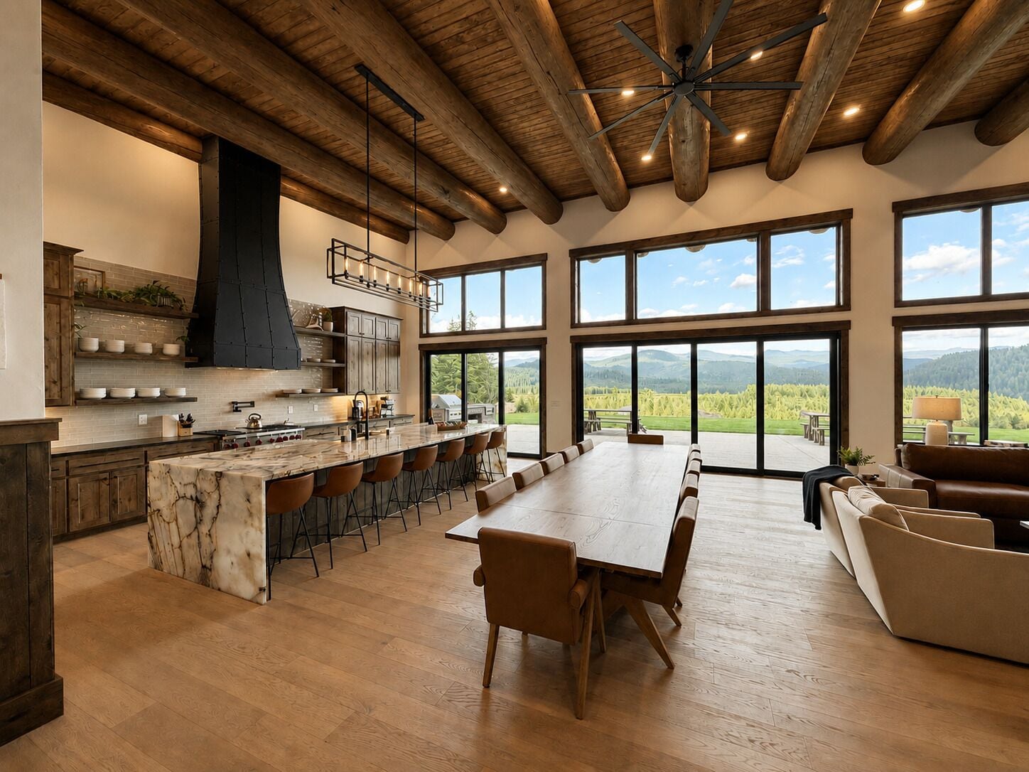 A spacious kitchen with a large island, bar seating, and a view of a mountainous landscape through large windows.