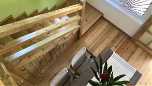 Un escalier en bois offrant une vue sur la salle à manger située en contrebas.