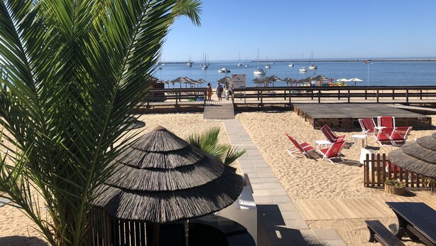 A beachside area with a wooden deck, lounge chairs, and umbrellas. - Sunny family villa with pool, 10 mins from the beach and centre! (Ferragudo)