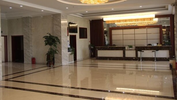 A spacious lobby with a polished floor, a reception desk, and a large chandelier. - Hengxiang Hotel (Aksay)