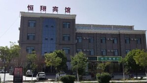 A multi-story building with a prominent sign at the top reading "恒翔宾馆". - Hengxiang Hotel (Aksay)