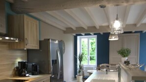 Una cucina moderna con mobili in legno, un frigorifero in acciaio inossidabile e una grande isola con lavello.