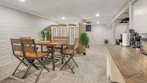 A modern kitchen with a wooden dining table, chairs, and a kitchen counter. - 7809 Hunters Moon Ln · Moon River Smart-Suite, near Interstate 44/airport (Springfield)