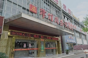 Un edificio con un gran letrero que dice 'Zhongguancun Commercial Hotel'.