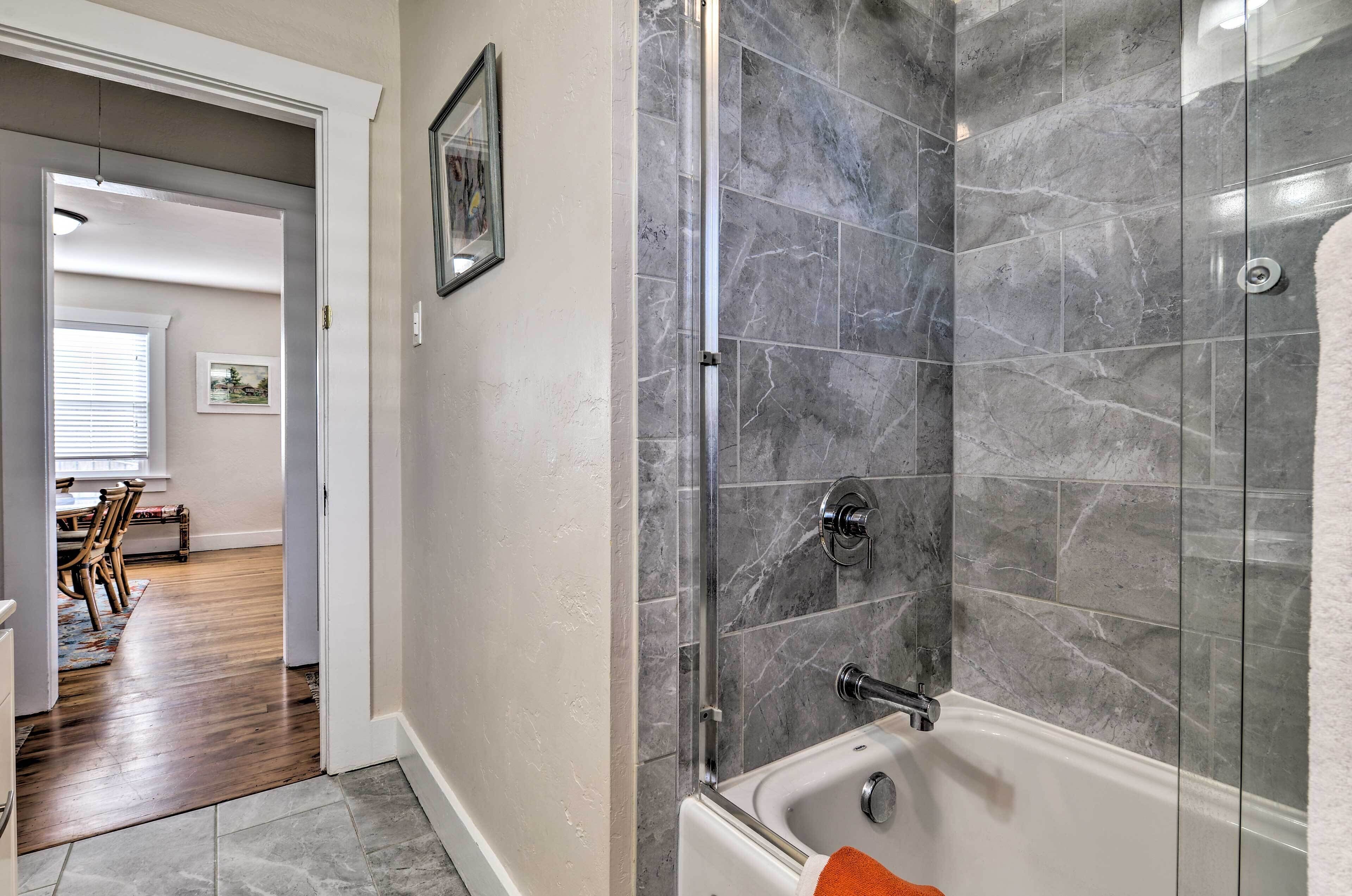 Une salle de bain avec une douche à parois de verre et une baignoire.