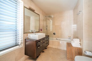 Un bagno moderno con un ampio specchio, due lavandini, una doccia e un WC.