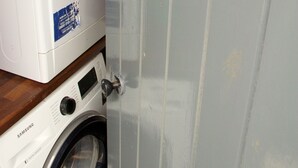Une buanderie équipée d’un lave-linge Samsung et d’un panneau indiquant qu’elle fait partie du complexe « Laundry Lodge ».