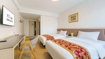 A hotel room with two beds, a desk, and a chair.