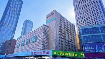 A high-rise building with multiple floors, large windows, and a prominent sign on the facade.