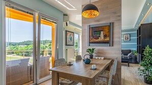 A modern dining area with a wooden table, chairs, and a painting on the wall.