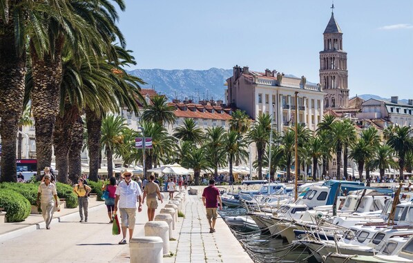 Stroll along the promenade lined with palm trees and take in the views of the water and surrounding architecture.