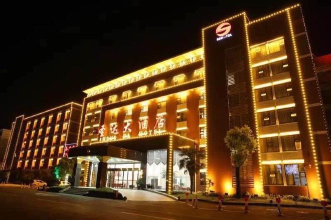 A multi-story hotel with illuminated signage and a prominent entrance.
