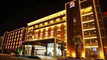 A multi-story hotel with illuminated signage and a prominent entrance.