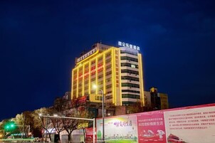 A multi-story hotel with illuminated signage and a prominent entrance.