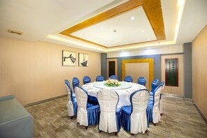 A conference room with a round table, blue and white chairs, and framed artwork on the walls. - Leju Hotel (Jiaozuo Dongfanghong Square) (Jiaozuo)