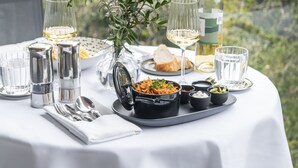 A table set outdoors with a white tablecloth, glasses, a bottle, and various dishes. - Casa Polanco Hotel Boutique (Mexico City)